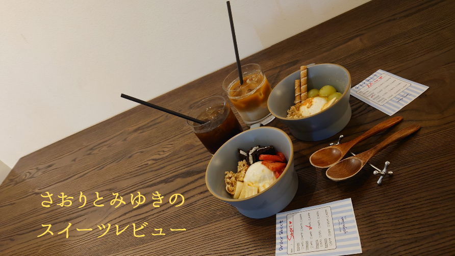 2つのアイスデザートとアイスコーヒーが並べられた木製テーブルに「さおりとみゆきのスイーツレビュー」と文字が書かれている