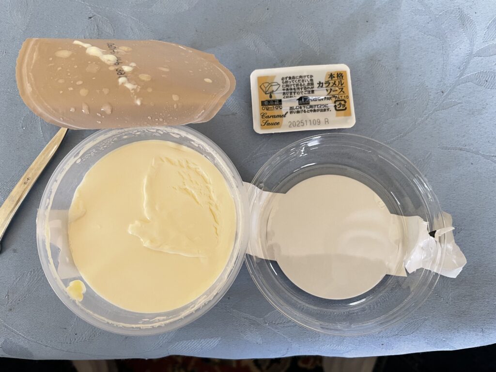 バニラプリンと添付されたカラメルソースのパッケージ。プリンは滑らかで、上にカラメルソースをかける準備が整っている。