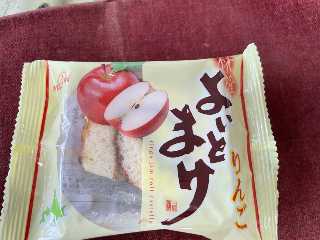 「よいとまけ りんご」のパッケージとりんごのイラストが描かれた個包装のお菓子の写真。