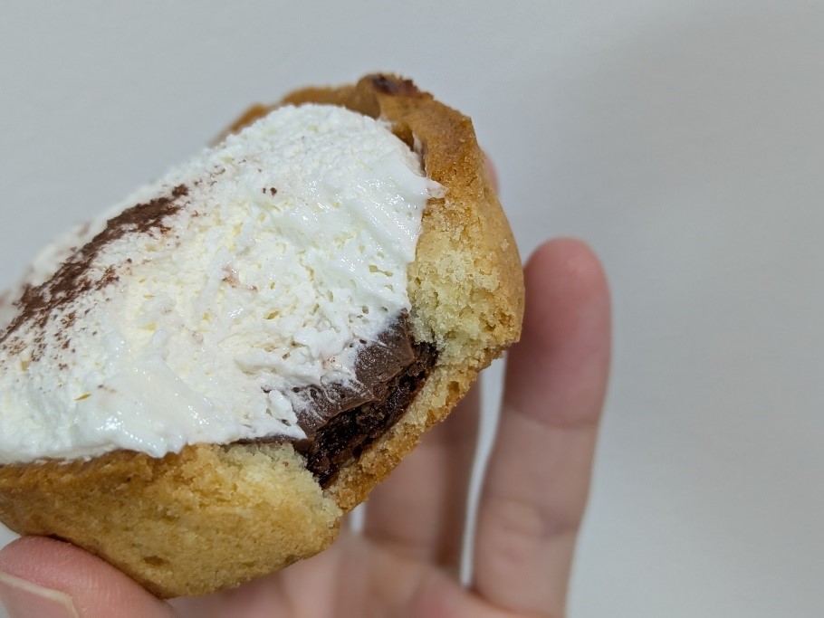 塩チョコタルトの側面。タルトの中にチョコレート層があり、上にクリームとココアパウダーが乗っている。