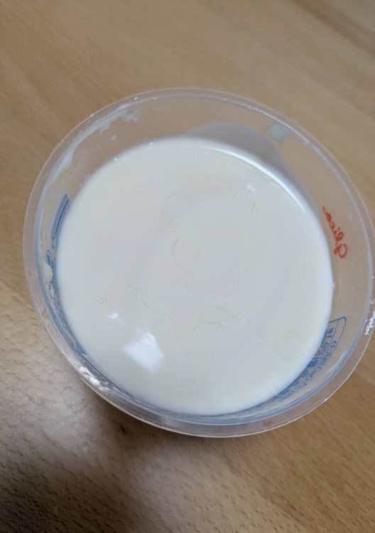 上から見た「とろ~りクリーム on プリン」。カップいっぱいに広がる、白くて滑らかなクリームの表面が写っている。