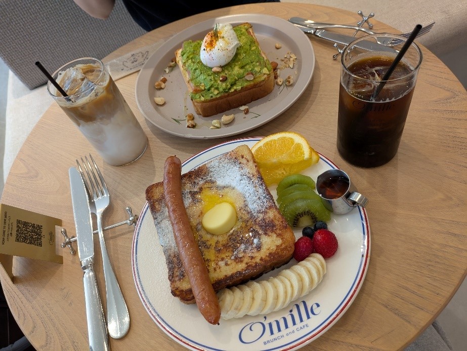 O’milleカフェで提供されるブランチセット。フレンチトーストとアボカドトースト、アイスコーヒーとカフェラテが並んでいる様子