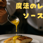 レストランの厨房で、シェフが焼き魚に黄色いレモンソースを丁寧にかけている様子。「魔法のレモンソース術」の文字入り。