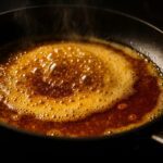 黒いフライパンの中で、バターが溶けて泡立ち、香ばしい焦がしバターになっている。